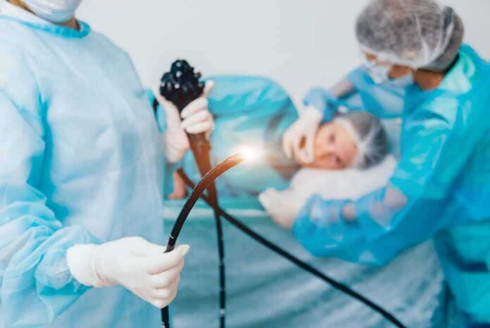 shutterstock_1275748081-1 Medical staff preparing endoscope near patient on hospital bed
