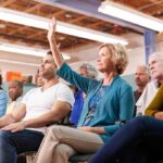 Brian Yorkey in a community meeting as a woman raises her hand