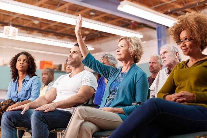 Brian Yorkey in a community meeting as a woman raises her hand