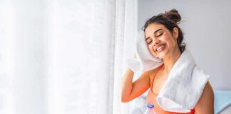Woman wiping sweat with towel after workout