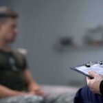 Therapist taking notes while man sits on couch