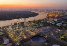 Benzene Nightmare in Niger Delta – WHO Limits Shattered Industrial oil refinery complex beside a river at dusk