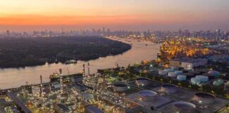 Industrial oil refinery complex beside a river at dusk