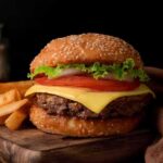 Study Shows How Specific Junk Foods Impact Life Expectancy Cheeseburger with lettuce and tomato on sesame bun