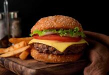 Cheeseburger with lettuce and tomato on sesame bun