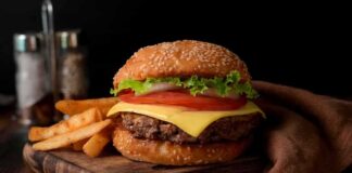Cheeseburger with lettuce and tomato on sesame bun