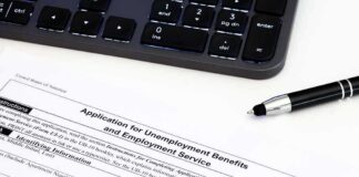 Unemployment benefits application form with keyboard and pen