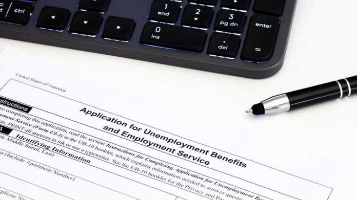 Unemployment benefits application form with keyboard and pen