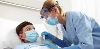 Nurse checks temperature of hospitalized boy