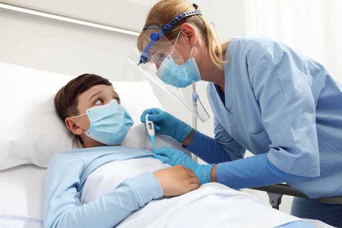 Nurse checks temperature of hospitalized boy