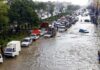 Flooded city street with stranded vehicles and traffic jam
