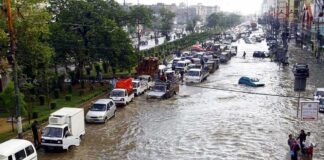 Flooded city street with stranded vehicles and traffic jam