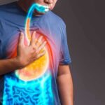 The impact of dietary emulsifiers on your gut health Person clutching chest with illustrated reflux and stomach overlay
