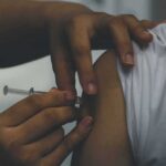 person receiving an injection in the upper arm