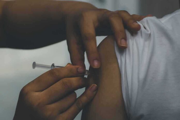 person receiving an injection in the upper arm