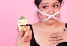 Mindful Eating Interventions for Weight Loss Management Woman with measuring tape over mouth holding a decorated cupcake