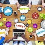 Wining an Argument Doesn’t Mean You are Right Top view of a collaborative workspace with social media icons and people using laptops