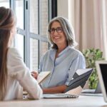 Smiling woman with gray hair talking in a modern office