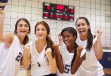 Female Sports: Missing Periods and Broken Bones Four female volleyball players celebrating in a gymnasium