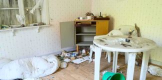 Cluttered room with overturned bucket and messy table