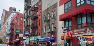 City street with brick buildings, fire escapes, and busy storefronts