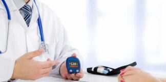 doctor showing a blood glucose meter to a patient