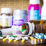 Stress and Inflammatory Bowel Disease: Breaking the Vicious Cycle Medicine pills and syringe on table with brown bottle
