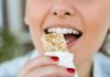 Person taking a bite of a granola bar