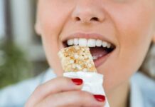 Person taking a bite of a granola bar