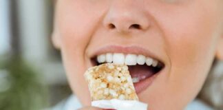 Person taking a bite of a granola bar