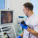 Bladder Cancer’s Silent Strike – The Forgotten Cancer Doctor holding endoscope beside monitor during procedure
