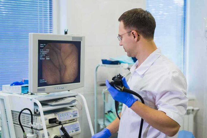 shutterstock_679625242 Doctor holding endoscope beside monitor during procedure