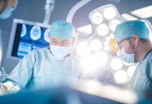 Surgeons in operating room under bright surgical lights