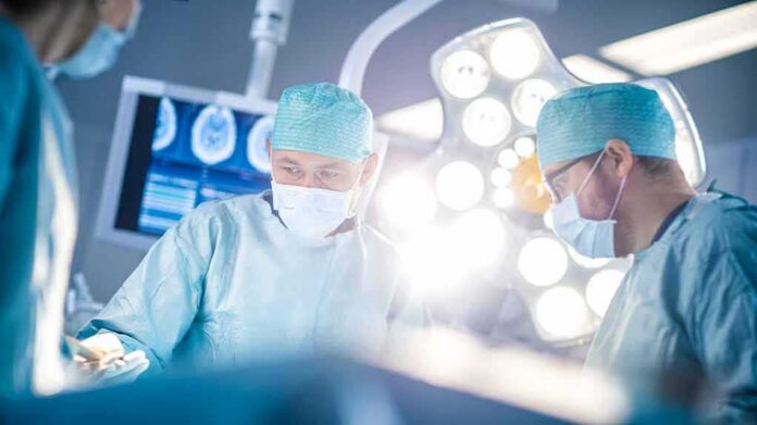 Surgeons in operating room under bright surgical lights