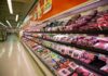 Grocery store meat aisle stocked with packaged beef and poultry