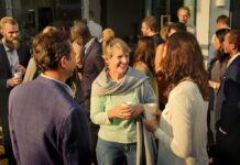 Friede Springer chatting with attendees at an outdoor networking event
