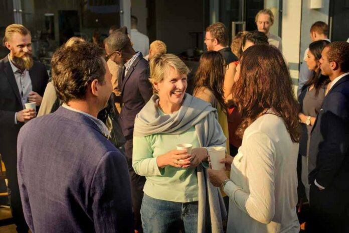 Friede Springer chatting with attendees at an outdoor networking event