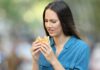 Woman looking displeased at a hamburger outdoors