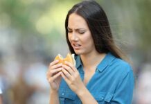 Woman looking displeased at a hamburger outdoors