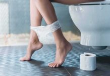 Your Stress Could Be Behind Your Latest Bathroom Emergency Person sitting on a toilet with underwear at ankles and toilet paper nearby