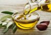 Olive oil pouring into a glass bowl