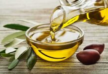 Olive oil pouring into a glass bowl