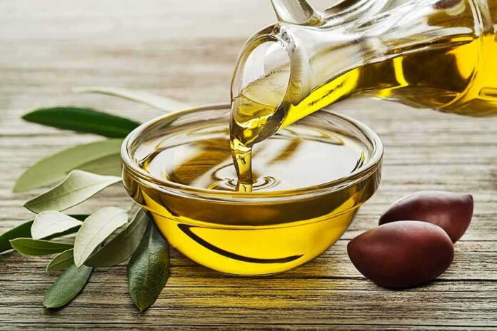 shutterstock_1171769116 Olive oil pouring into a glass bowl