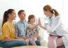 Doctor high-fives a smiling child during family visit
