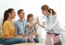Doctor high-fives a smiling child during family visit