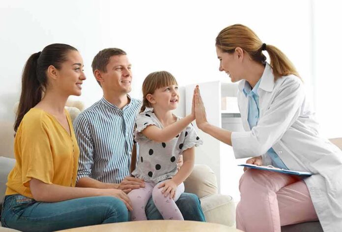 Doctor high-fives a smiling child during family visit