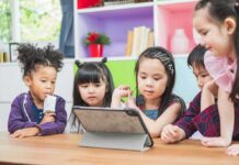 children gathered around a tablet at a table