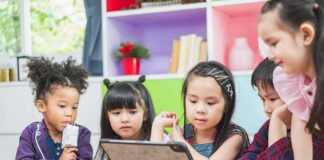 children gathered around a tablet at a table