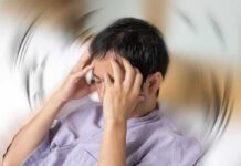 Person holding head with spinning blur effect