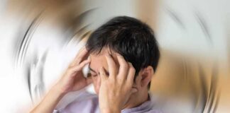 Person holding head with spinning blur effect